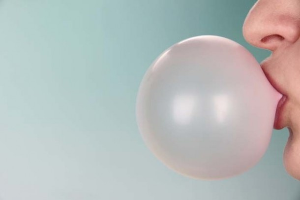 用咀嚼口香糖在明亮的背景下咀嚼口香糖的人