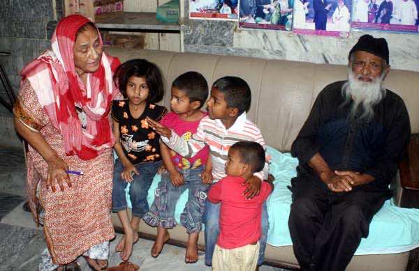 巴基斯坦卡拉奇，3月2日:著名社会工作者阿卜杜勒·萨塔尔·艾德希(Abdul Sattar Edhi)于2014年3月2日星期日在卡拉奇的艾德希之家与四个孩子合影，这些孩子是由于贫困而由亲戚移交给他们的。(S.Imran Ali/PPI Images)。