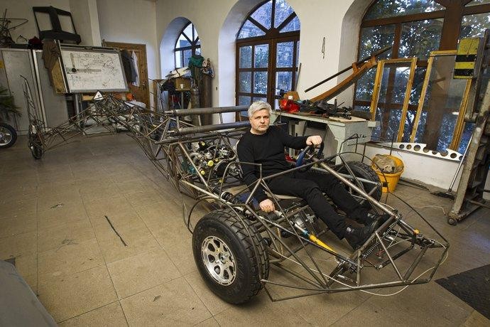 Stefan Klein在飞行汽车的骨架上拍照。你可以看到传动轴在…